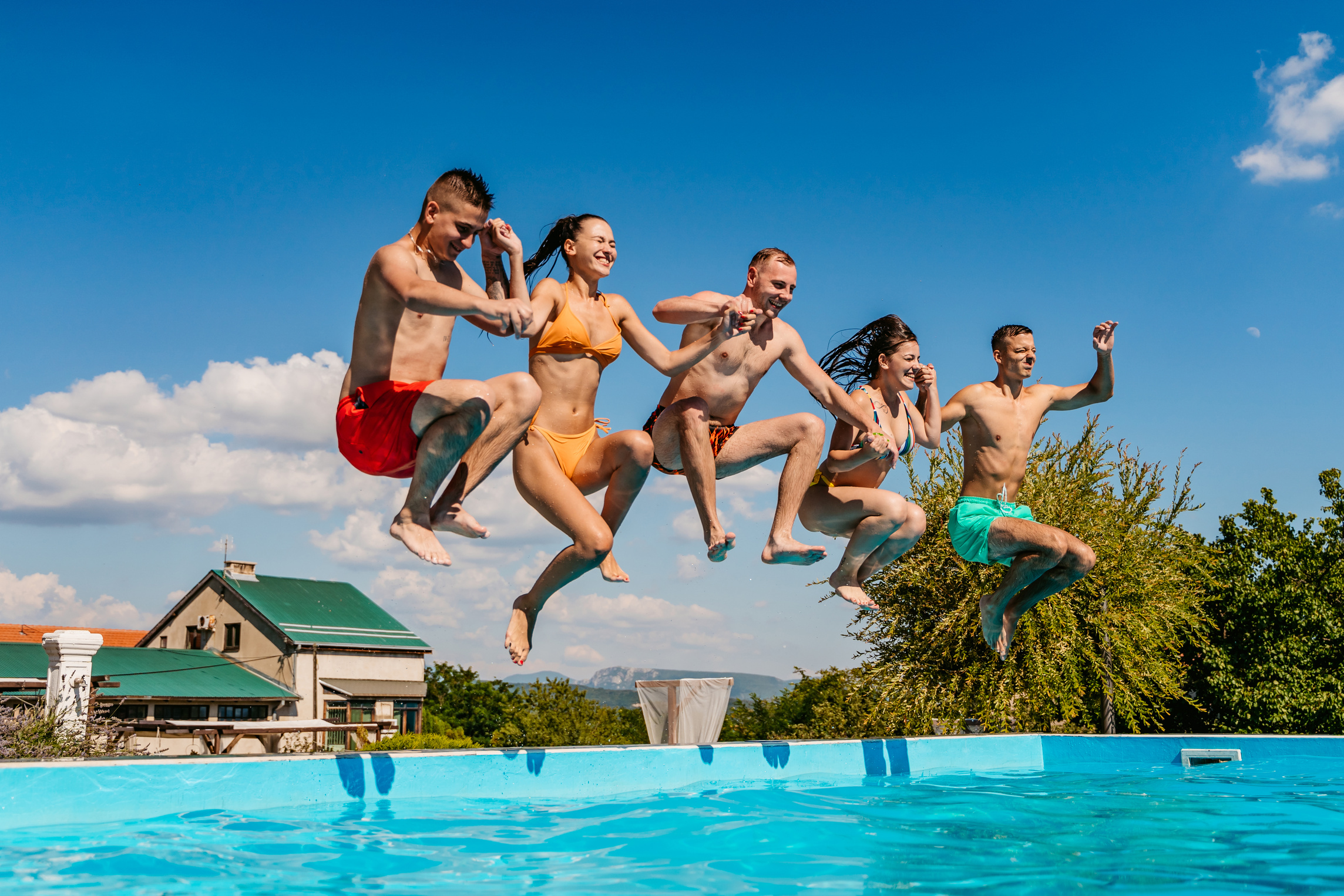 Friends jumping in swimming pool